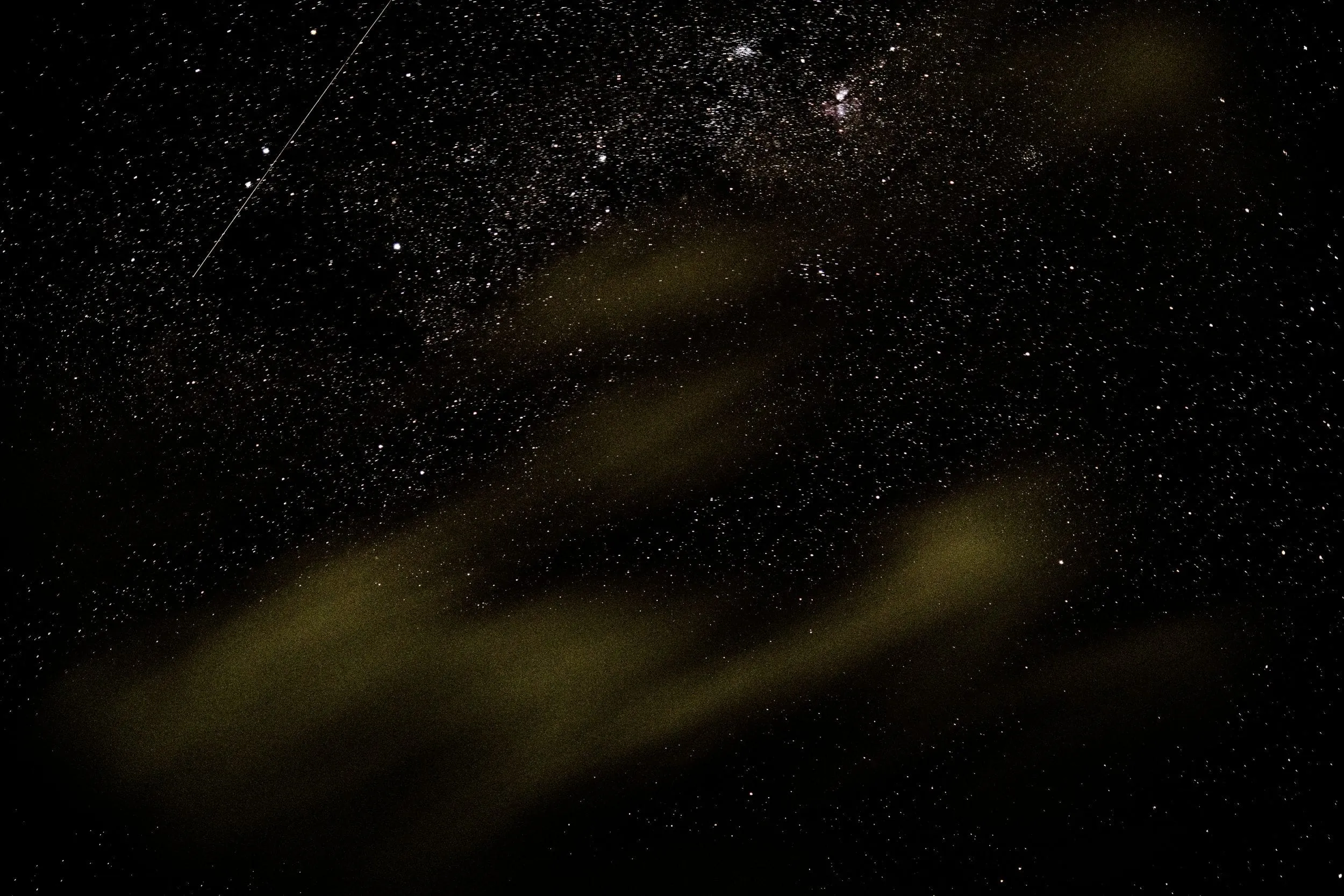 Stars behind drifting smoke from the evening fire