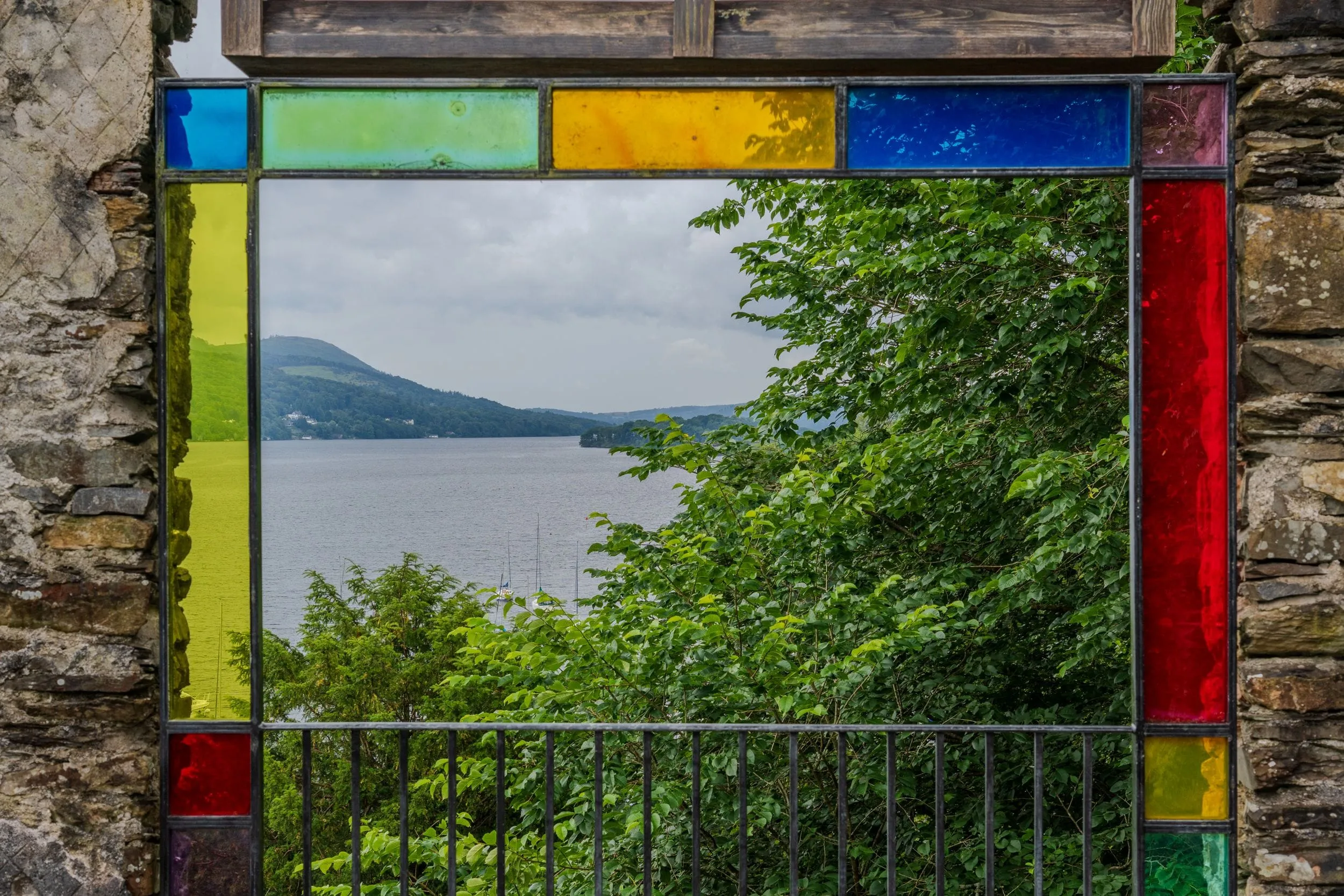 A lake framed by the coloured glass of a hillside viewing station