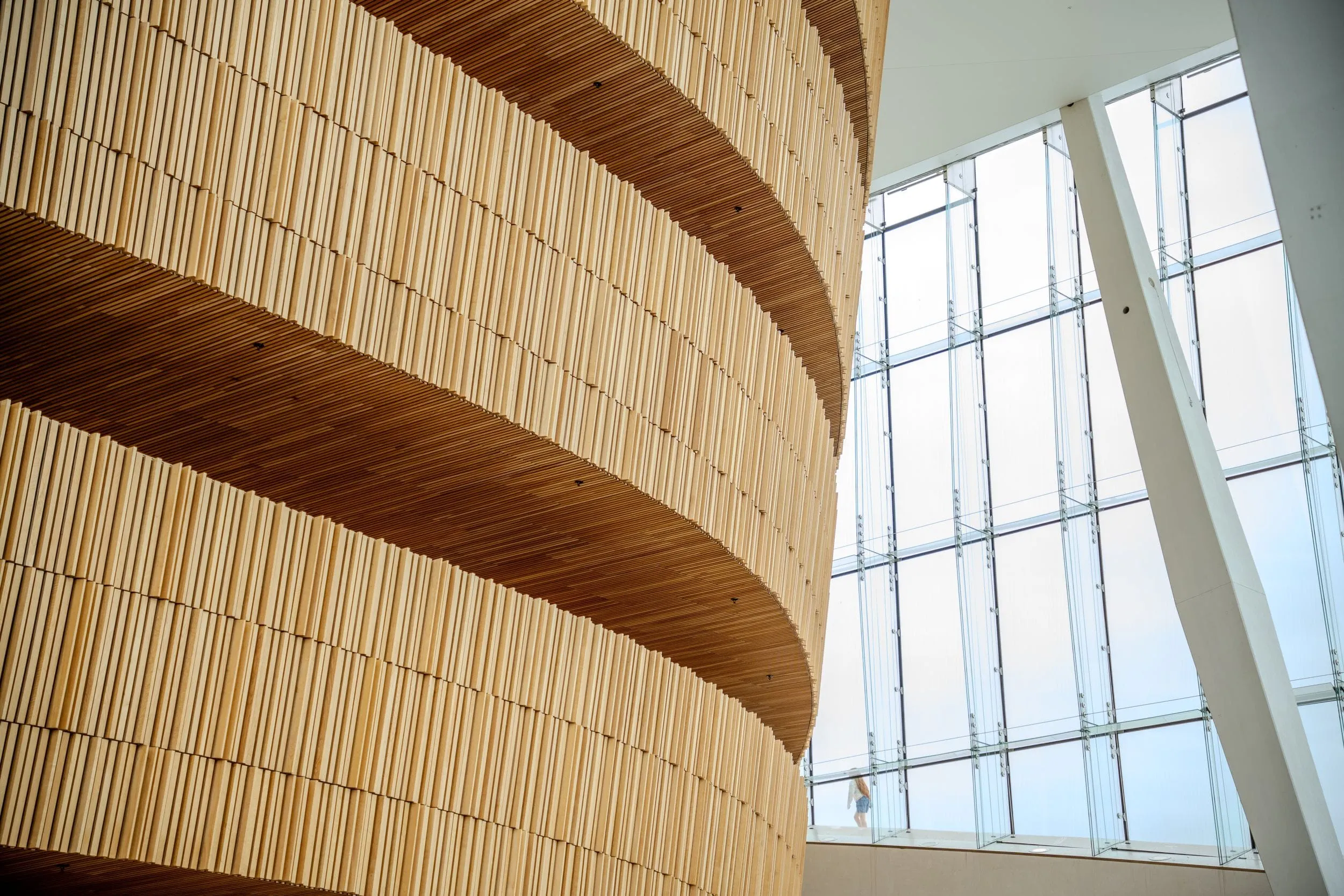 Curved timber battens and angled glass inside the Oslo Opera House foyer