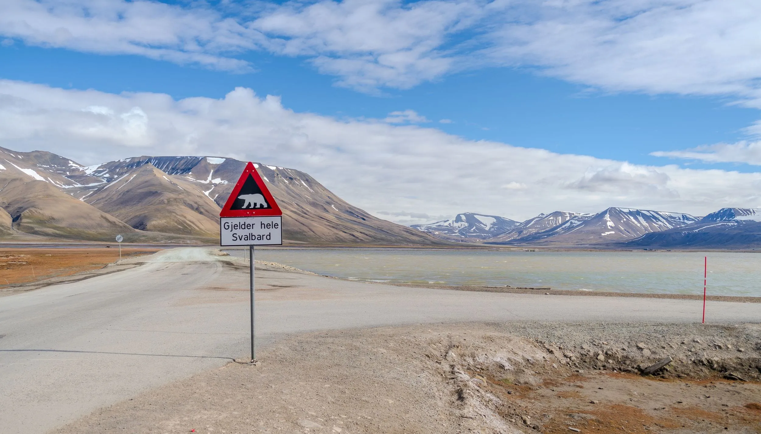 A polar-bear warning sign — Gjelder hele Svalbard — on the road out of Longyearbyen
