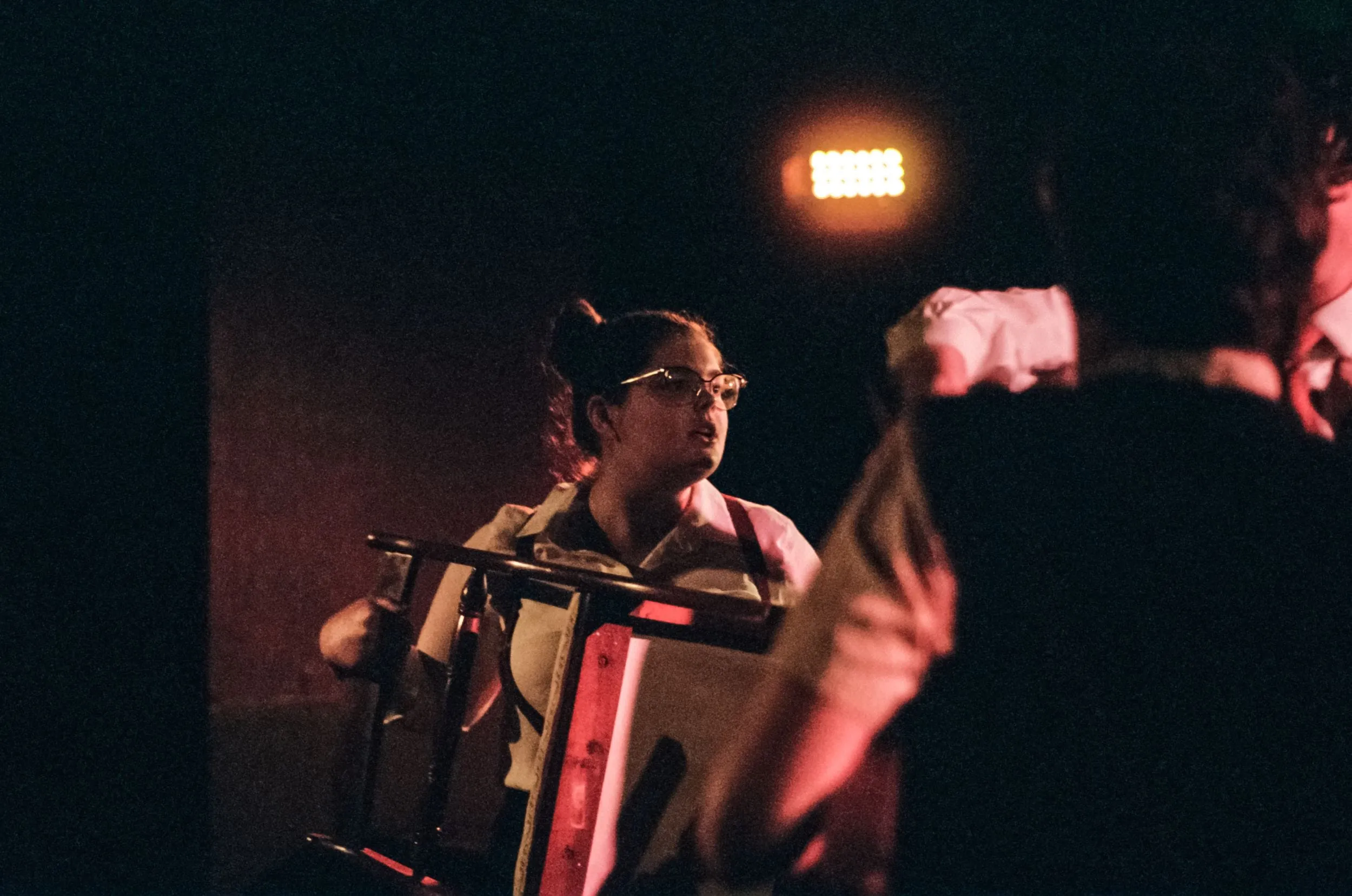 Meg clutches the toy drum in the shadows as a figure passes in the foreground