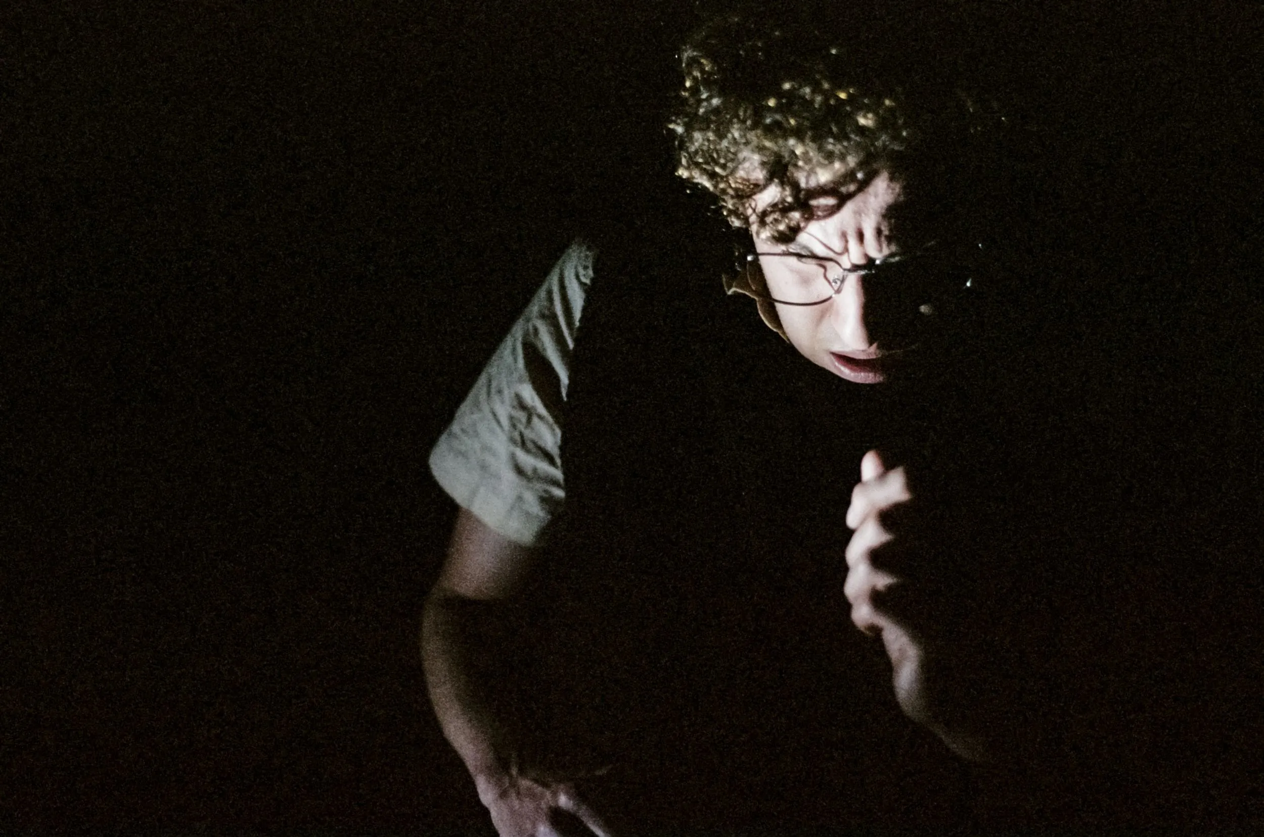 Stanley peers out of total darkness, hand raised to his chest
